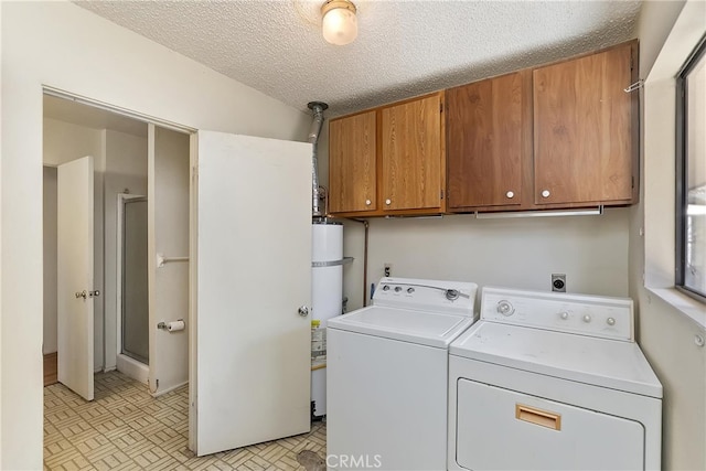 laundry room featuring cabinet space, a textured ceiling, washing machine and dryer, and gas water heater