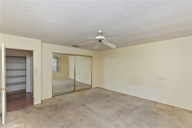 unfurnished bedroom with a closet, a ceiling fan, carpet flooring, and a textured ceiling