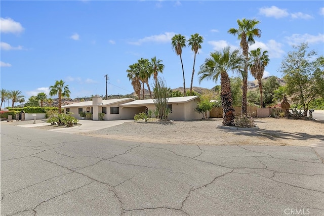 ranch-style home with fence and stucco siding