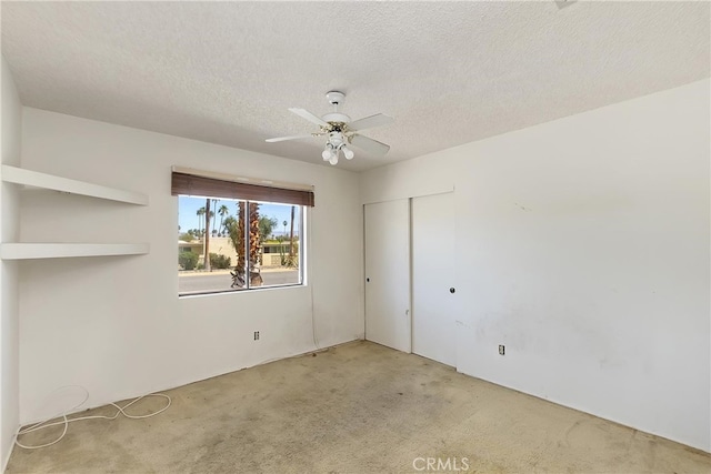 carpeted empty room with a textured ceiling and ceiling fan