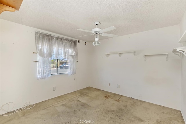 unfurnished room with a ceiling fan, a textured ceiling, and light carpet