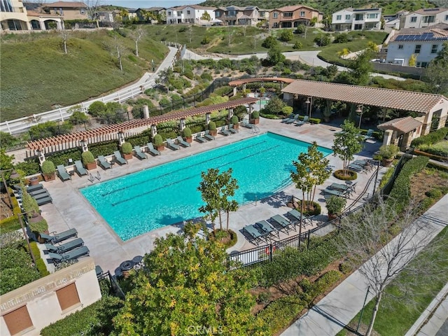 community pool with a patio area and fence