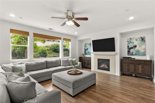 living area featuring recessed lighting, a tiled fireplace, a ceiling fan, visible vents, and wood finished floors