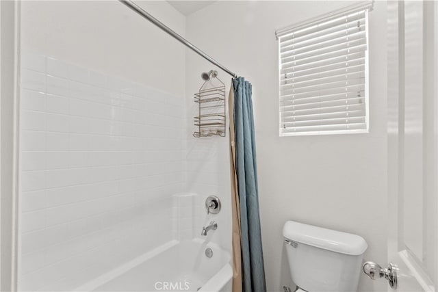 full bathroom featuring shower / bath combo with shower curtain and toilet