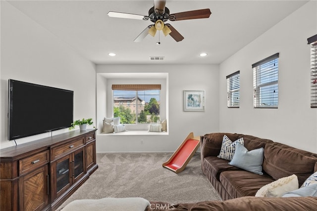 carpeted living area featuring baseboards, visible vents, a wealth of natural light, and ceiling fan