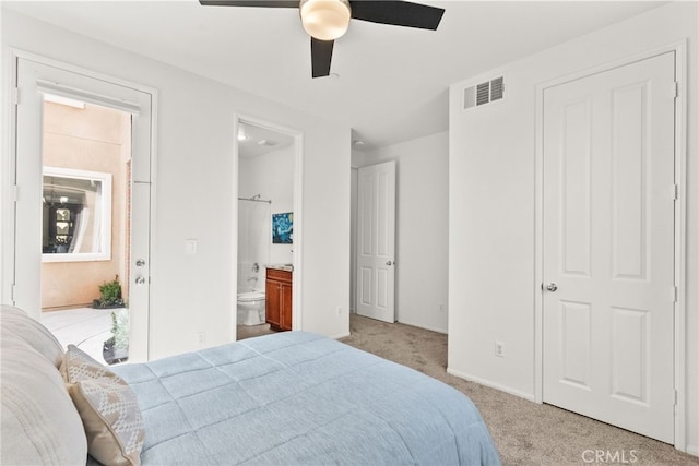 carpeted bedroom featuring visible vents, a ceiling fan, and connected bathroom