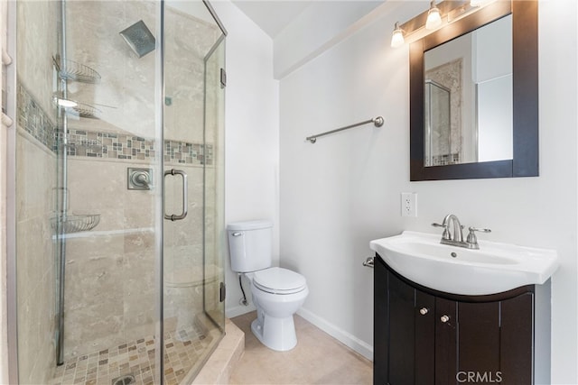 full bath with a shower stall, toilet, vanity, baseboards, and tile patterned flooring