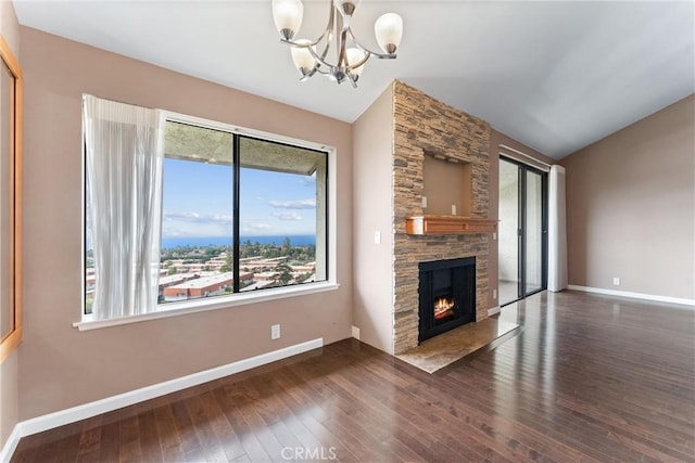unfurnished living room featuring baseboards, a chandelier, hardwood / wood-style flooring, a fireplace, and lofted ceiling