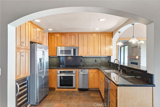 kitchen with appliances with stainless steel finishes, a sink, beverage cooler, tasteful backsplash, and recessed lighting