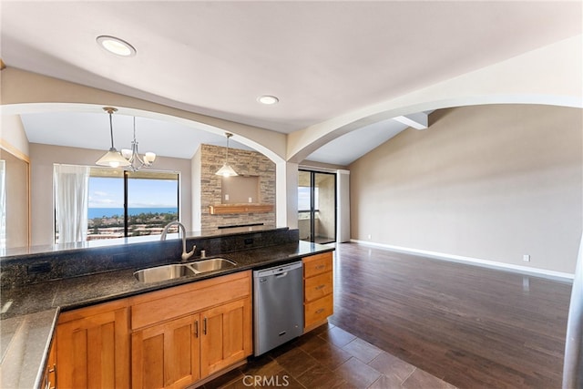 kitchen featuring vaulted ceiling, dishwasher, a sink, arched walkways, and open floor plan