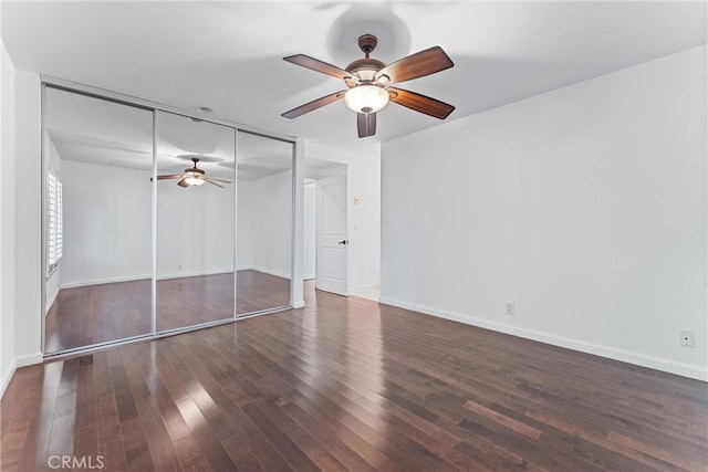 unfurnished bedroom with a closet, wood finished floors, baseboards, and ceiling fan