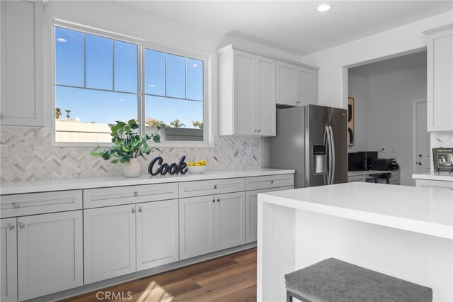 kitchen featuring stainless steel fridge, dark wood-style flooring, recessed lighting, decorative backsplash, and light countertops