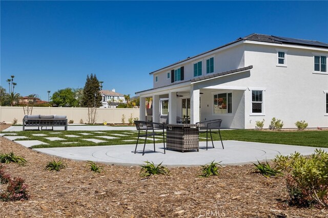 rear view of property featuring a fenced backyard, a yard, a patio, stucco siding, and an outdoor living space