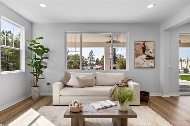 living area featuring baseboards, a ceiling fan, wood finished floors, and recessed lighting
