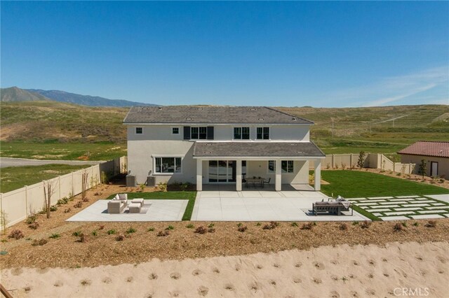 rear view of property with a fenced backyard, a patio, and stucco siding