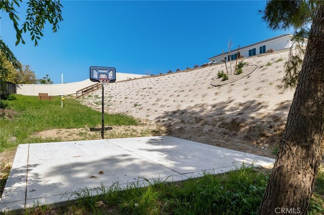 view of patio with community basketball court and fence