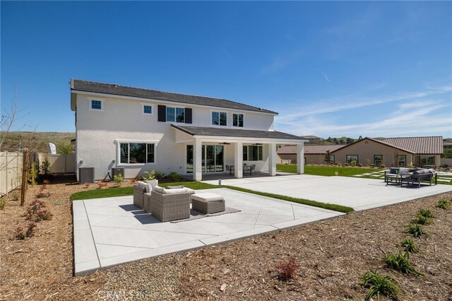 rear view of house with a fenced backyard, cooling unit, stucco siding, a patio, and an outdoor living space