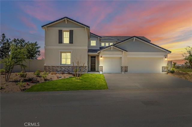 traditional home with stucco siding, an attached garage, stone siding, and concrete driveway