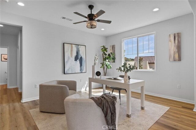 office area with baseboards, wood finished floors, visible vents, and ceiling fan