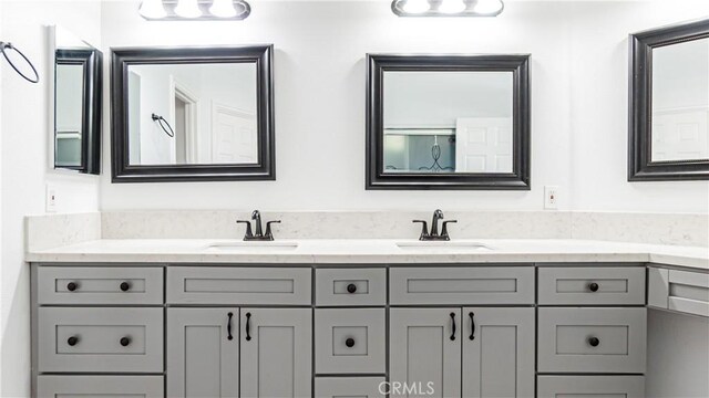 bathroom with a sink and double vanity
