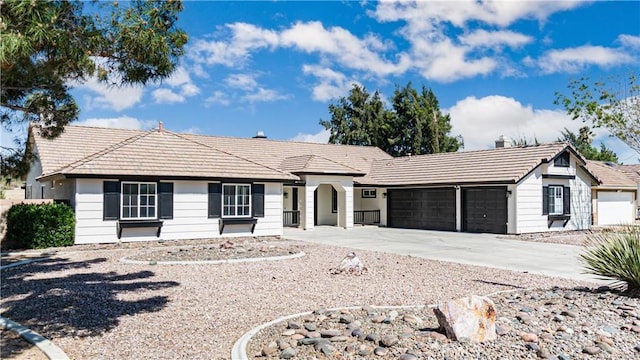ranch-style house with an attached garage, a tiled roof, and concrete driveway