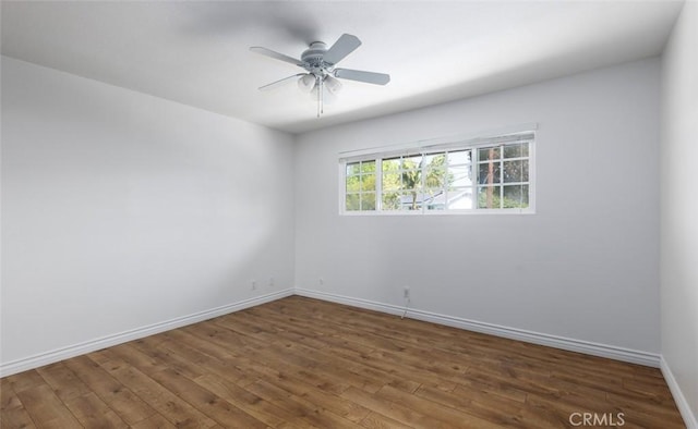 spare room featuring baseboards, a ceiling fan, and wood finished floors