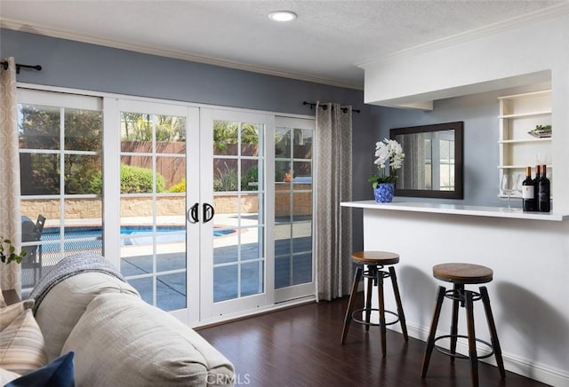 entryway featuring a healthy amount of sunlight, crown molding, dark wood-style flooring, and french doors