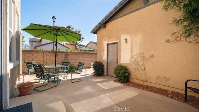 view of patio featuring fence and outdoor dining area