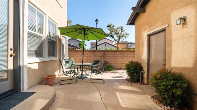 view of patio with outdoor dining space and fence