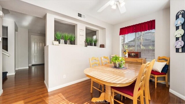 dining room featuring baseboards, wood finished floors, visible vents, and a ceiling fan