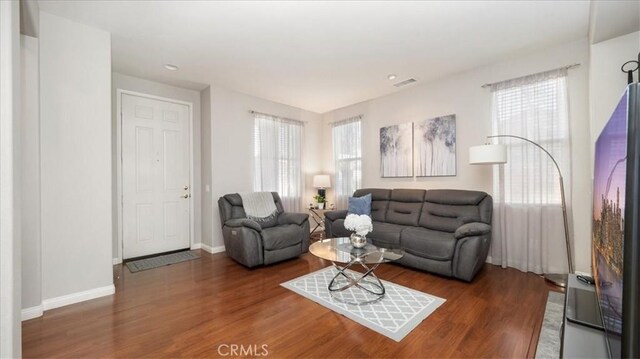 living area with baseboards and wood finished floors
