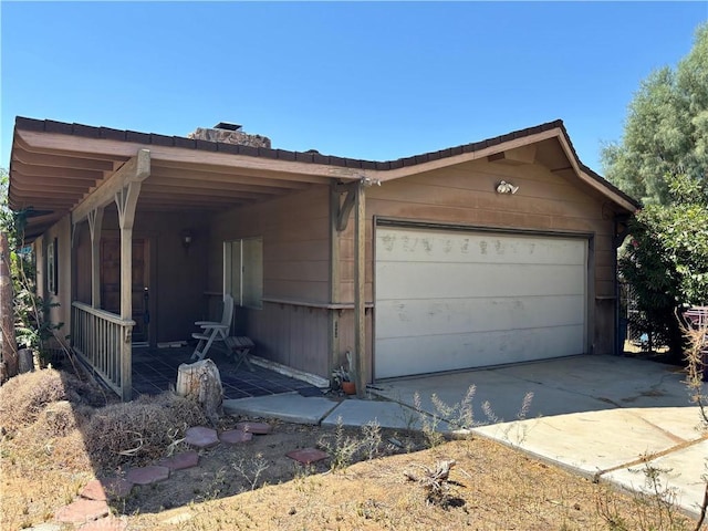 7890 Mariposa Trl, Yucca Valley, CA 92284 - view of front of house featuring a porch, driveway, and an attached garage
