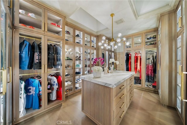 spacious closet with a chandelier, light wood-style floors, and visible vents