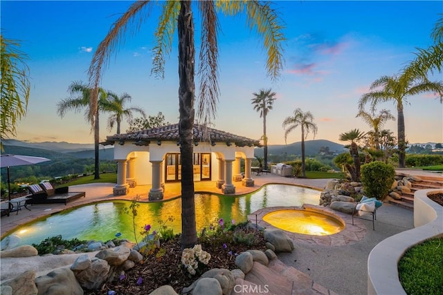 view of community featuring a jacuzzi, a pool, and a patio