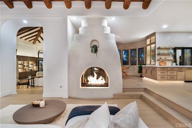 living room with recessed lighting, beamed ceiling, and light wood-type flooring