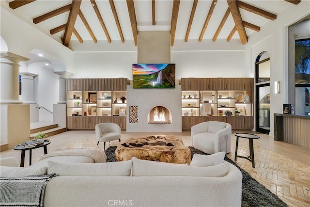 interior space with beamed ceiling, high vaulted ceiling, and decorative columns