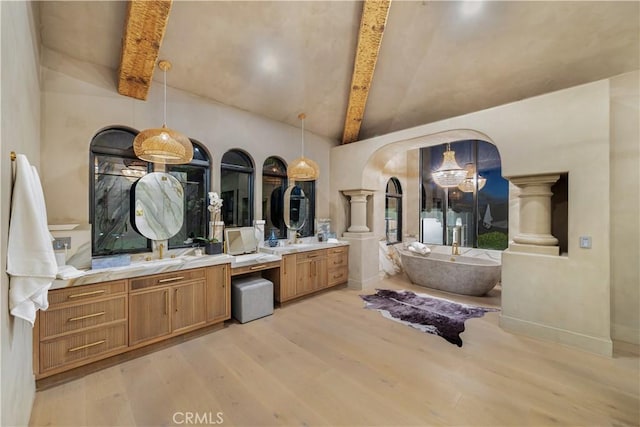 bathroom featuring beamed ceiling, a freestanding tub, wood finished floors, vanity, and high vaulted ceiling