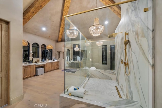 full bathroom with a notable chandelier, beamed ceiling, vanity, and a marble finish shower