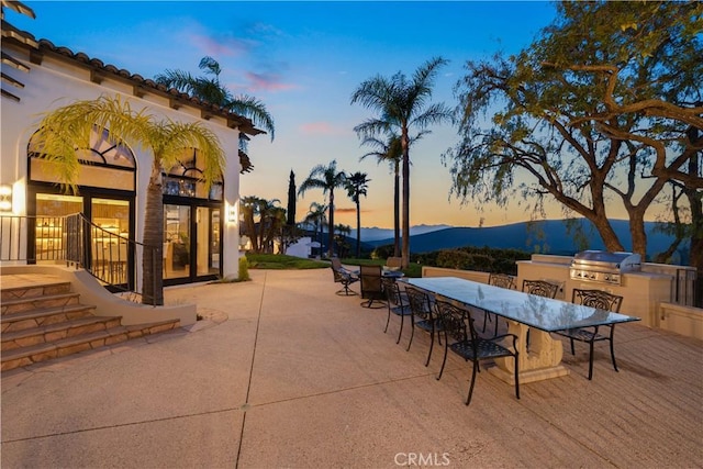 view of patio with a grill, an outdoor kitchen, and outdoor dining space