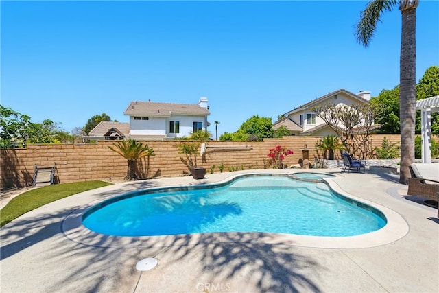 view of pool with a pool with connected hot tub, a patio, and a fenced backyard
