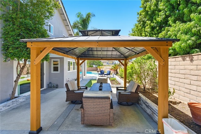 view of patio featuring an outdoor pool, a gazebo, and a fenced backyard