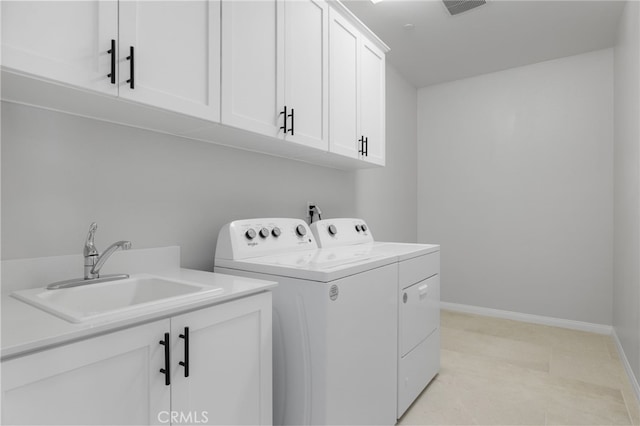 laundry room featuring cabinet space, washer and clothes dryer, baseboards, and a sink