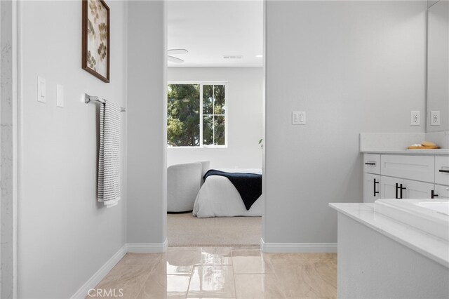 bathroom with visible vents, vanity, baseboards, and marble finish floor