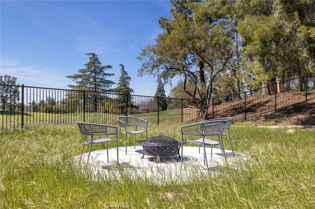 surrounding community featuring fence and an outdoor fire pit