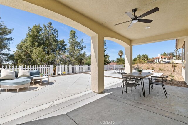 view of patio with outdoor dining area, a ceiling fan, and a fenced backyard