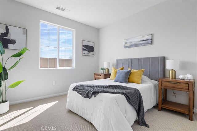 carpeted bedroom with visible vents and baseboards