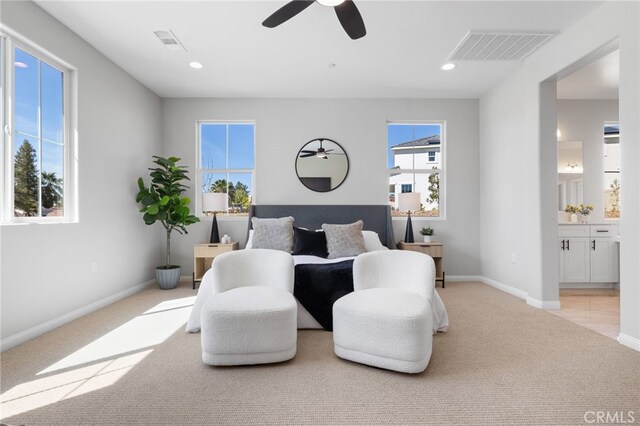 bedroom with carpet floors, ensuite bathroom, visible vents, and baseboards