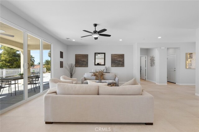 living area featuring light colored carpet, baseboards, a ceiling fan, and recessed lighting