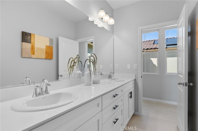 full bath with baseboards, a sink, and double vanity