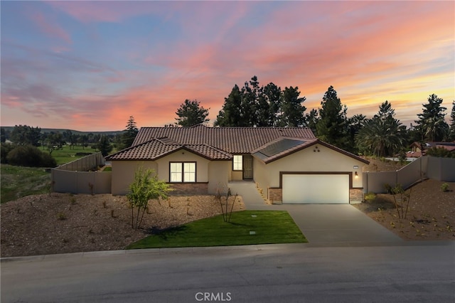 ranch-style home featuring fence, a tile roof, and stucco siding